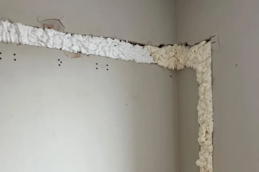 Bruzda w ścianie pod instalację klimatyzacji, poprowadzona pod sufitem i w narożniku pomieszczenia